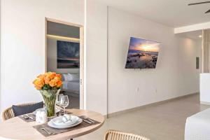 a dining room table with a vase of flowers on it at Double Suite Luxury Retreat 605 Tower in Cabo San Lucas