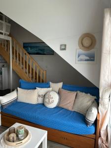 ein blaues Sofa in einem Zimmer mit einer Treppe in der Unterkunft Appartement vue mer le Croisic in Le Croisic