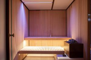 a room with a wooden wall with a bench in it at Brightwater by Rove Sauna Pool & Outdoor Spaces in Freetown