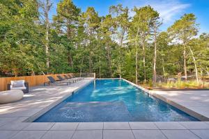 a swimming pool in a backyard with benches and trees at Brightwater by Rove Sauna Pool & Outdoor Spaces in Freetown