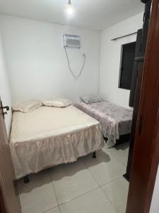 Una habitación con dos camas y aire acondicionado. en Apto Ninho Sereno em ilheus, en Ilhéus