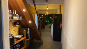 un couloir menant à une cuisine équipée d'un réfrigérateur dans l'établissement Cervejaria Guest House, à Île de Boipeba