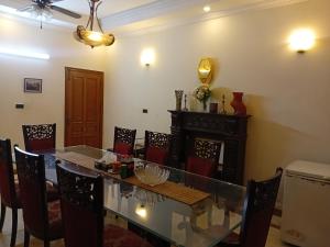 una sala da pranzo con tavolo e sedie in vetro di Naim Ullah Tiwana a Lahore