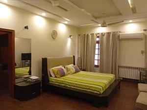 una camera da letto con un letto e uno specchio di Naim Ullah Tiwana a Lahore