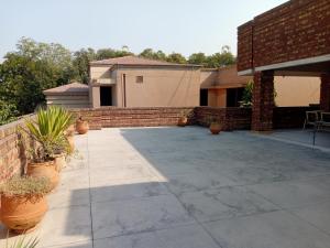 un patio con piante in vaso e un muro di mattoni di Naim Ullah Tiwana a Lahore