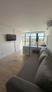 a living room with a couch and a view of the ocean at Bright on the avenue in Mar del Plata