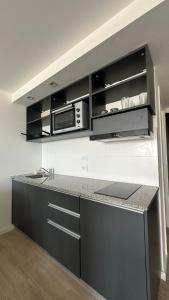 a kitchen with a counter top with a microwave at Bright on the avenue in Mar del Plata