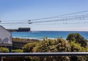 a view of a beach with a pier and the ocean at Kiama Dreams in Kiama +3 photos