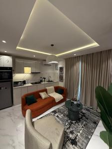 a living room with an orange couch and a kitchen at Rorex cozy cityview 1 bedroom apartment in Lekki