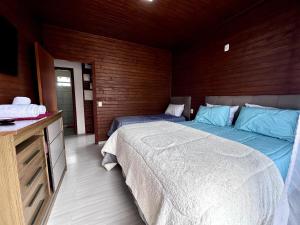 - une chambre avec 2 lits et un mur en bois dans l'établissement House Guarujá 02 em Lages SC próximo ao Shopping, à Lages