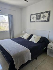 a bedroom with a bed with a blue blanket and a window at PALERMO APART 1 in Buenos Aires