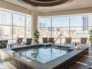 a hot tub in the middle of a room with windows at Fairmont Austin in Austin