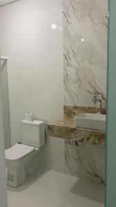 ein weißes Badezimmer mit Toilette und Waschbecken in der Unterkunft Casa ampla e luxuosa em Caldas do Jorro in Tucano