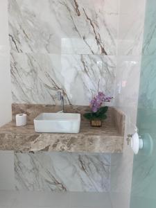 ein Badezimmer mit einem Waschbecken und einer Marmorwand in der Unterkunft Casa ampla e luxuosa em Caldas do Jorro in Tucano