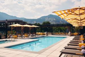 a pool at a hotel with chairs and umbrellas at Limelight Boulder in Boulder