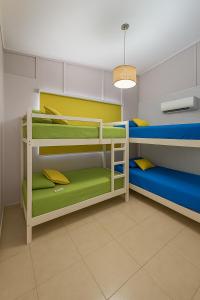 ein Zimmer mit drei Etagenbetten in Blau und Grün in der Unterkunft Paradise Point Coronado Casa de Playa con Piscina, BBQ y Starlink in Playa Coronado + 26 Fotos