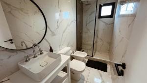 a bathroom with a sink and a toilet and a mirror at Casa Molino - Casa en Complejo Land Houses A Dos cuadras de Cruz del Sur, Chapadmalal - Hola Sur in Chapadmalal +9 photos