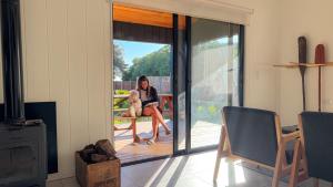 a woman sitting on a bench with a dog at Casa Molino - Casa en Complejo Land Houses A Dos cuadras de Cruz del Sur, Chapadmalal - Hola Sur in Chapadmalal