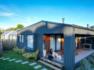 two people standing on the porch of a tiny house at Casa Molino - Casa en Complejo Land Houses A Dos cuadras de Cruz del Sur, Chapadmalal - Hola Sur in Chapadmalal