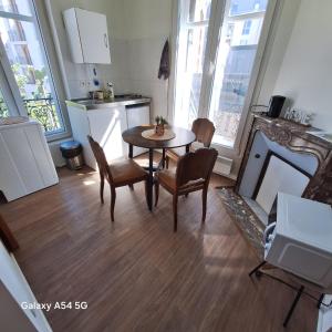 eine Küche und ein Esszimmer mit Tisch und Stühlen in der Unterkunft Vasso 2 in Nancy