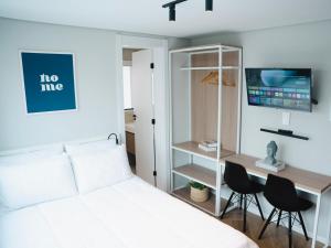 um quarto com uma cama e uma escrivaninha com duas cadeiras em Apê Itaim Bibi - Soft Opening em São Paulo