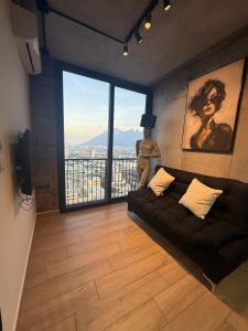 Una sala de estar con un sofá y una ventana grande. en BARRIO W -The best place to rest in downtown MTY, en Monterrey