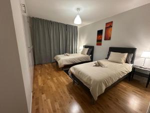 deux lits dans une chambre avec parquet dans l'établissement Noah longstay Kungsfågelgatan, à Västerås