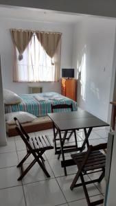 a bedroom with a bed and a table and chairs at Kitinet na Praia de Botafogo in Rio de Janeiro