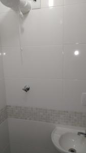 a bathroom with a white tub and a sink at Kitinet na Praia de Botafogo in Rio de Janeiro +15 photos