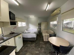 a small room with a bed and a kitchen with a table at NRMA Bairnsdale Riverside Holiday Park in Bairnsdale +27 photos