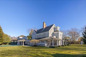 a large white house with a large yard at Oceanstone by Rove Villa w Pool & Beach Access in Southampton