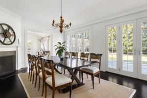 a dining room with a table and chairs and a fireplace at Oceanstone by Rove Villa w Pool & Beach Access in Southampton