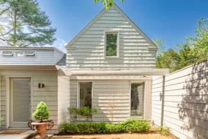 a white house with a fence in front of it at Cowhill Cottage by Rove Home with Pool & Lounge in Wainscott