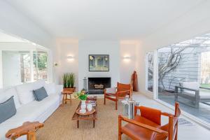 a living room with a white couch and chairs at Cowhill Cottage by Rove Home with Pool & Lounge in Wainscott