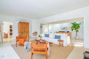 a living room with a white couch and chairs at Cowhill Cottage by Rove Home with Pool & Lounge in Wainscott