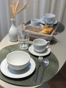 a table with plates and utensils on a table at Luxury Studio for 4 People - Allianz Park in Sao Paulo +22 photos