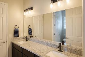 een badkamer met twee wastafels en een grote spiegel bij Dove Mountain Gem! in Marana +32 foto's