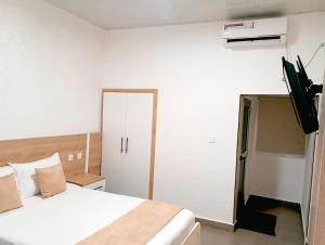 a bedroom with a bed and a television in it at Hotel du Golfe de Guinée in Conakry