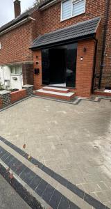 un edificio de ladrillo con un estacionamiento delante de él en The Dorking Hideaway, en Dorking