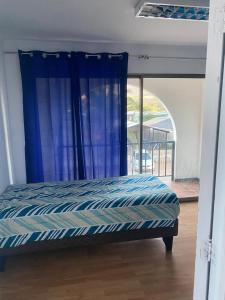 Bett in einem Zimmer mit einem blauen Vorhang in der Unterkunft Hotel Del Valle in Illapel