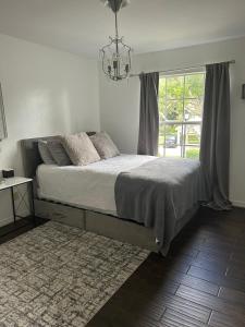 a bedroom with a bed with a chandelier and a window at Beautiful 2 Bedroom 2 Bathroom Condo in Naples