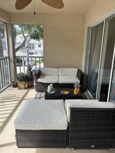 a screened in porch with a couch and a table at Beautiful 2 Bedroom 2 Bathroom Condo in Naples