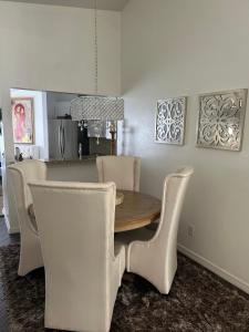a dining room with a wooden table and white chairs at Beautiful 2 Bedroom 2 Bathroom Condo in Naples +3 photos
