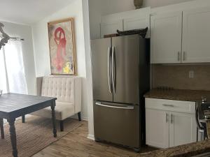 a kitchen with a stainless steel refrigerator and a table at Beautiful 2 Bedroom 2 Bathroom Condo in Naples