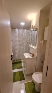 a bathroom with a toilet and a sink and a shower at Apartamentul ALB in Buşteni +49 photos