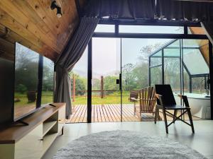 a room with a large window and a table and chairs at chalé okinawa in Gonçalves