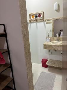 une salle de bain avec un lavabo et un miroir dans l'établissement Apartamento Centro Guriri 3 Quartos, à São Mateus
