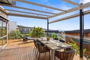 a patio with a table and chairs on a deck at Boston Beach House - BYO Linen in Lorne