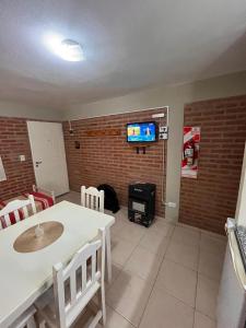 ein Wohnzimmer mit einem weißen Tisch und einem Kamin in der Unterkunft Cabañas Don Lelio 2 in Mina Clavero