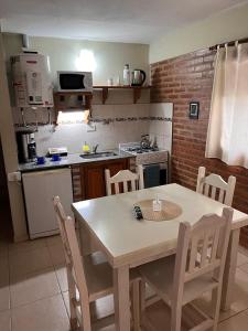 eine Küche mit einem Tisch und Stühlen in einer Küche in der Unterkunft Cabañas Don Lelio 2 in Mina Clavero